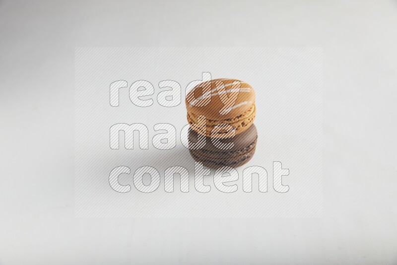 45º Shot of of two assorted Brown Irish Cream, and Brown Dark Chocolate macarons on white background