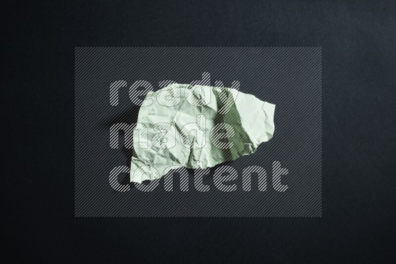 Green paper sheet on black background