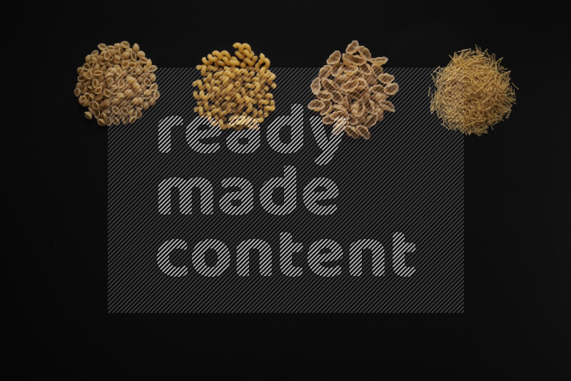 Different pasta types in 4 bunches on black background