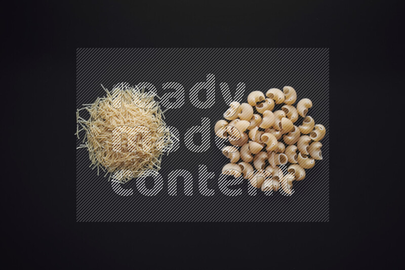 Different pasta types in bunches on black background