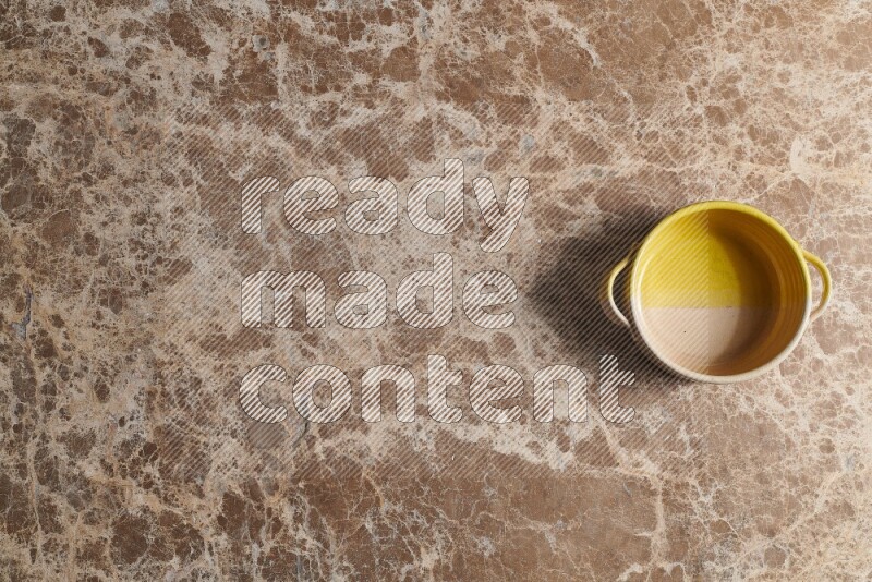 A multicolored pottery bowl on beige marble background