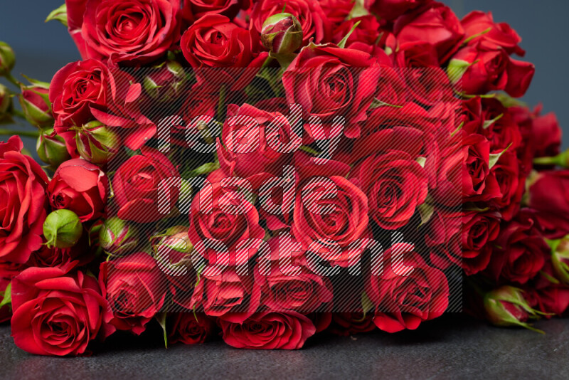 A luxurious bouquet of red roses on black marble background