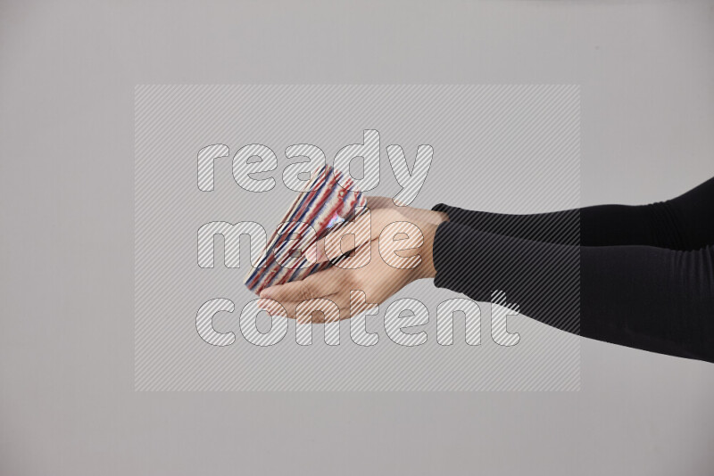 A woman in black abaya holding different pottery essentials in different positions