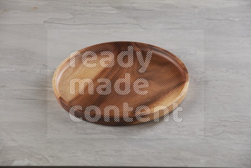 brown wood round plate on grey textured countertop