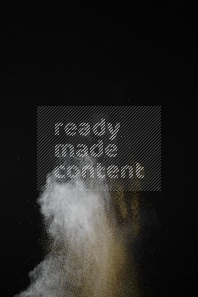 A side view of brown powder explosion on black background