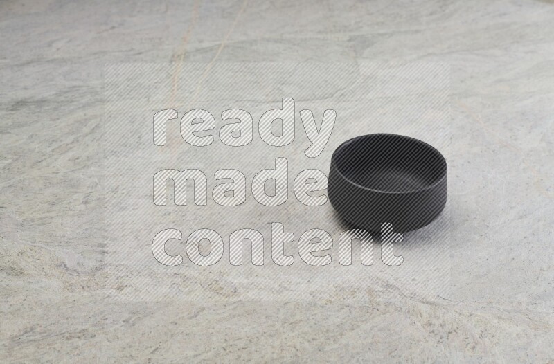 A black pottery bowl on grey marble background