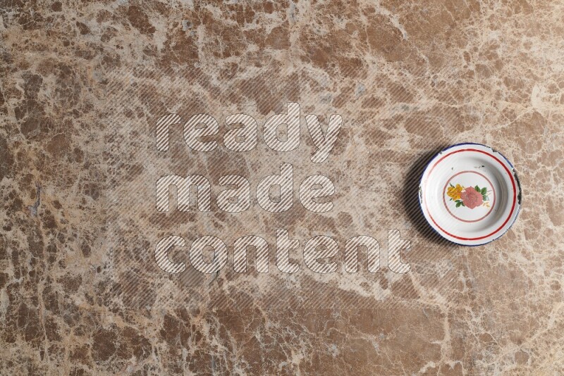 صحن معدني عتيق على خلفية من الرخام البيج