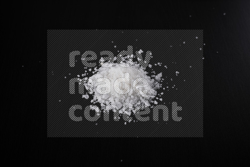 حفنة من ملح البحر الخشن على خلفية سوداء