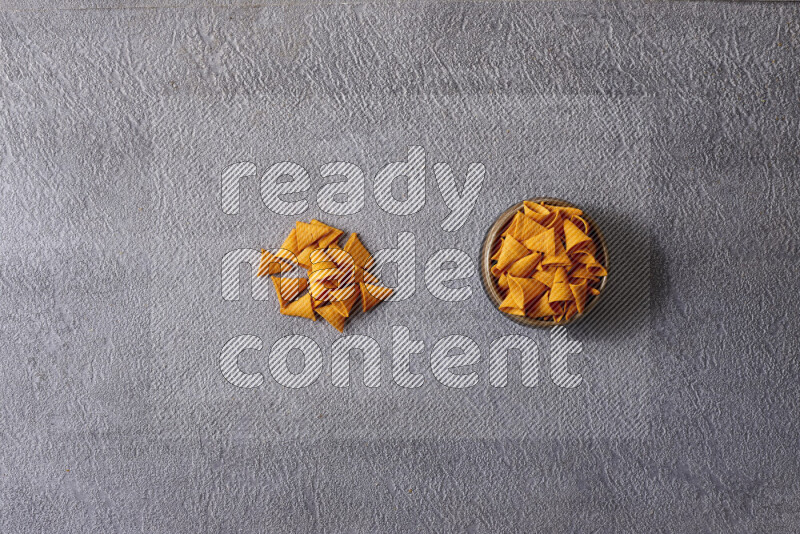 Assorted snacks in pottery bowls on grey background