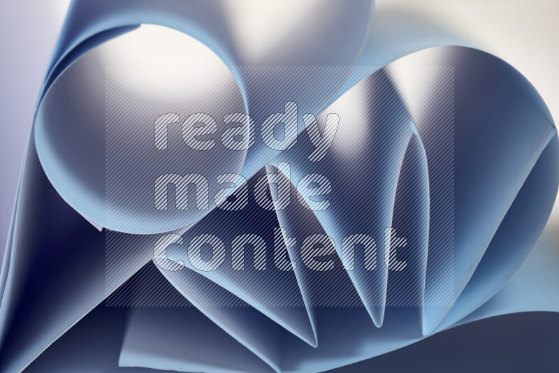 An artistic display of paper folds creating a harmonious blend of geometric shapes, highlighted by soft lighting in blue tones