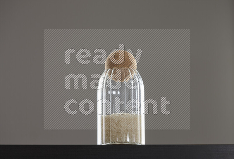 White rice in a glass jar on black background