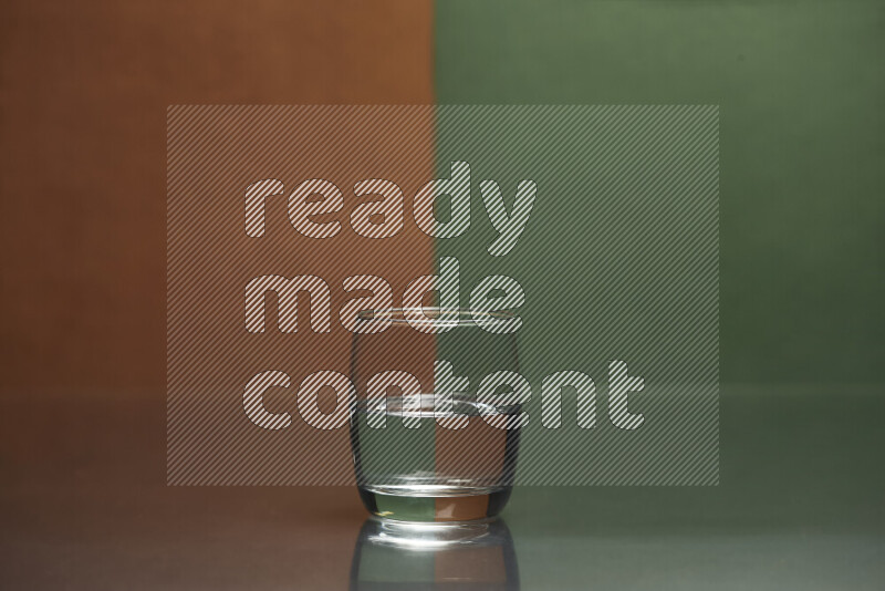 The image features a clear glassware filled with water, set against brown and dark green background