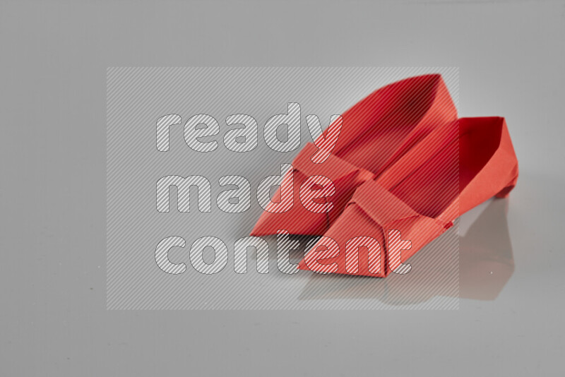 Origami shoes on grey background