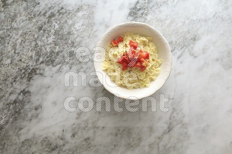 White bowl full of pasta on grey marble background