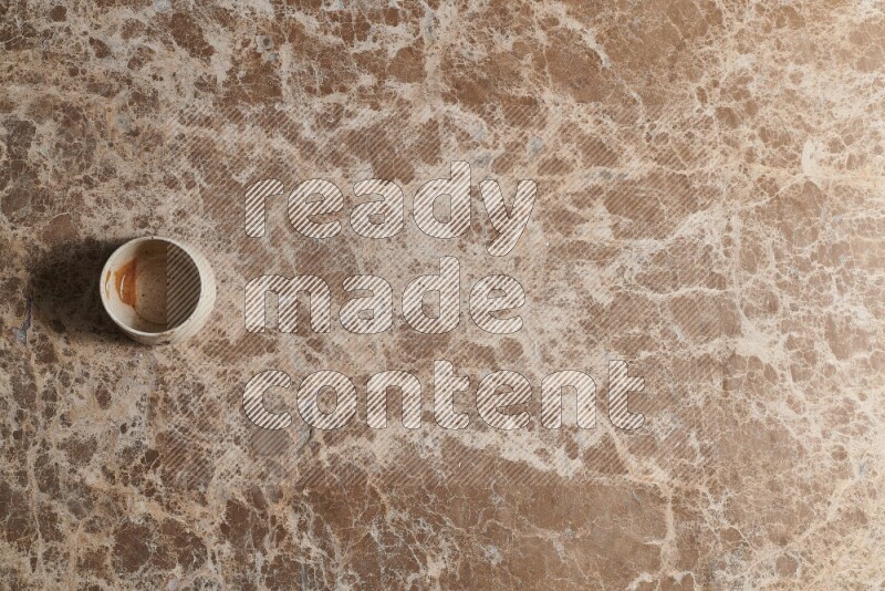 A multicolored pottery bowl on beige marble background