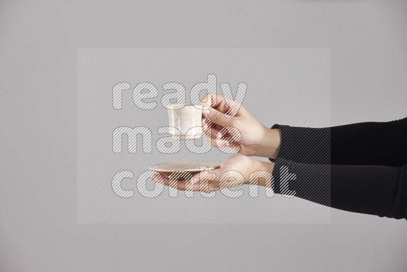 A woman in black abaya holding different pottery essentials in different positions