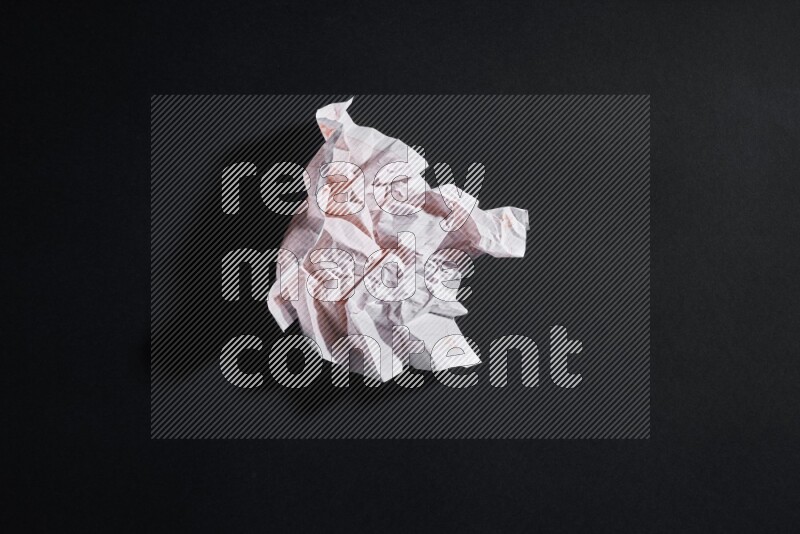 Crumpled notebook sheet on black background