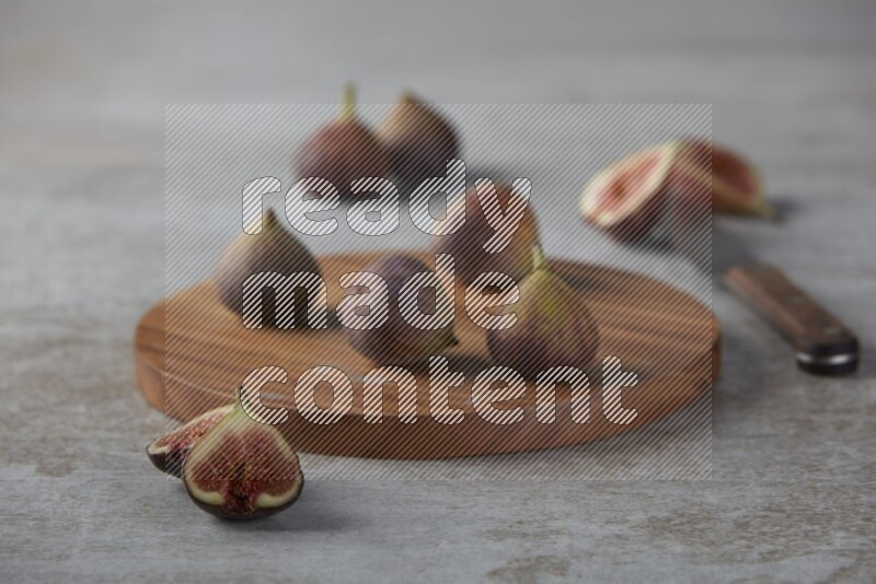 Fresh Figs on a wooden board on a textured grey background