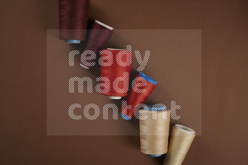 A red collection of sewing and tailoring tools arranged on a brown background