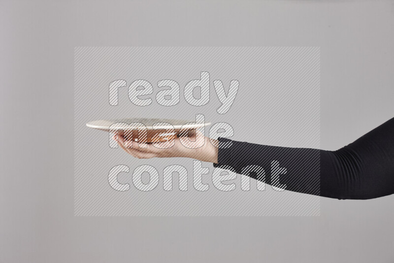 A woman in black abaya holding different pottery essentials in different positions