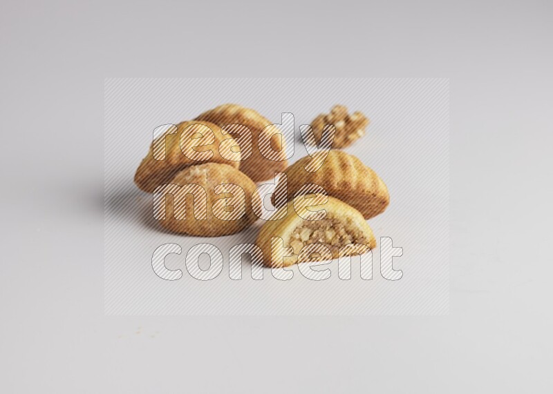 Five Pieces of Maamoul filled with walnut paste  one of them is cut with direct on white background