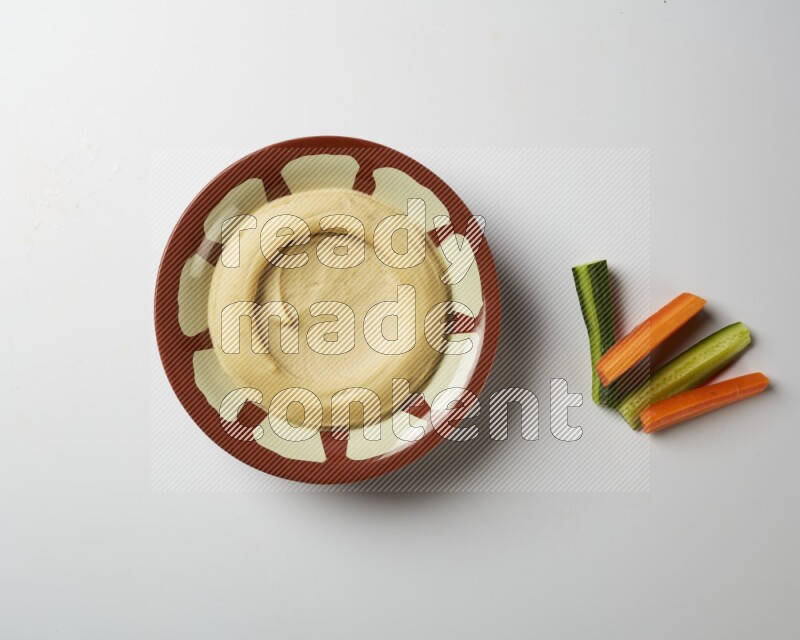 Plain hummus in a traditional plate on a white background
