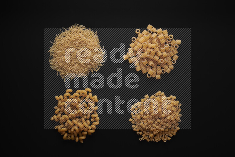 Different pasta types in bunches on black background