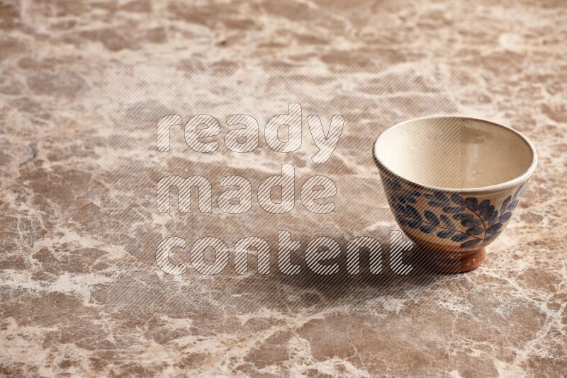 A decorative pottery bowl on beige marble background