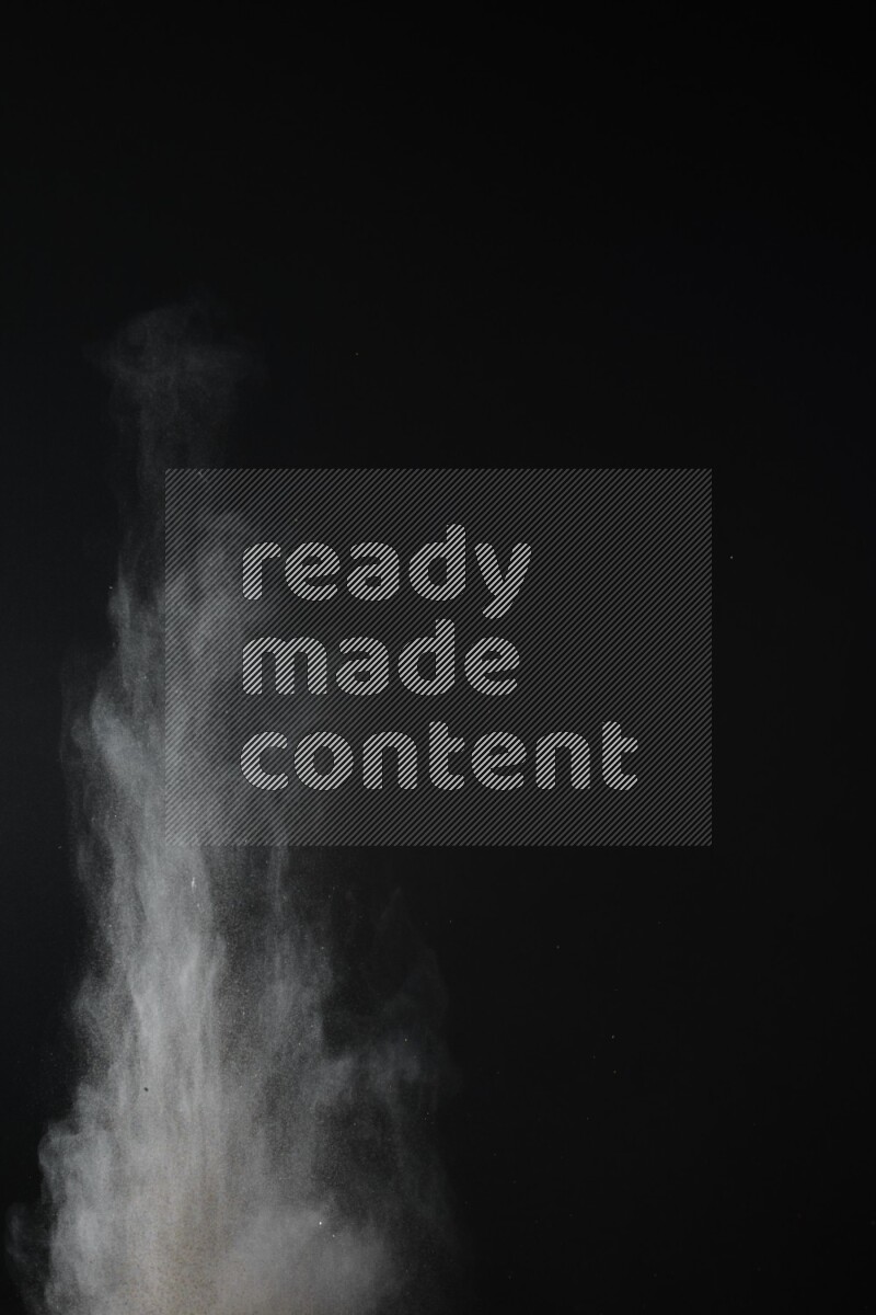 A side view of brown powder explosion on black background