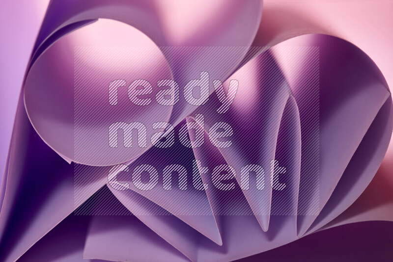 An artistic display of paper folds creating a harmonious blend of geometric shapes, highlighted by soft lighting in purple tones