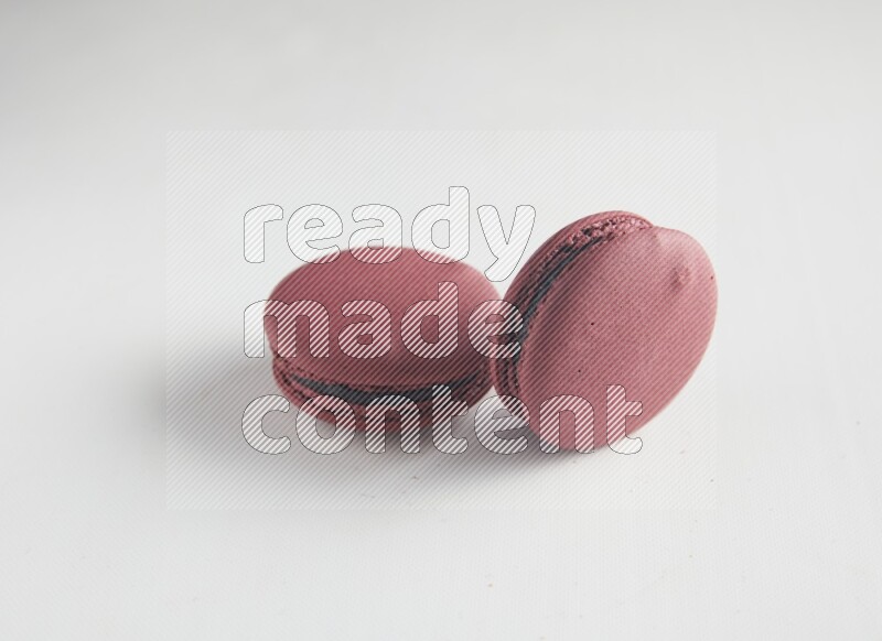 45º Shot of two Red Cherry macarons on white background