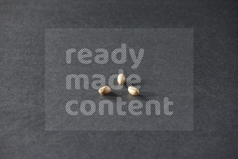 3 peeled peanuts on a black background in different angles
