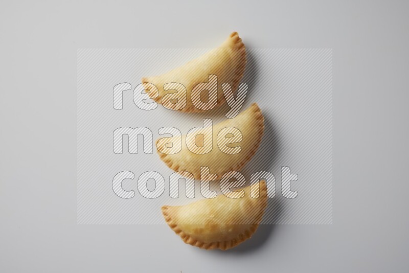 Three fried sambosa from a top angle on a white background