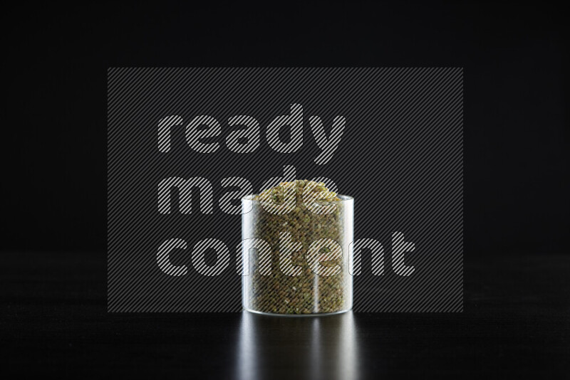 Freekeh in a glass jar on black background