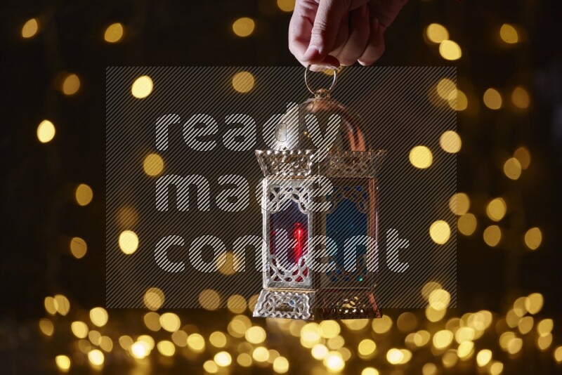 A traditional ramadan lantern surrounded by glowing fairy lights in a dark setup