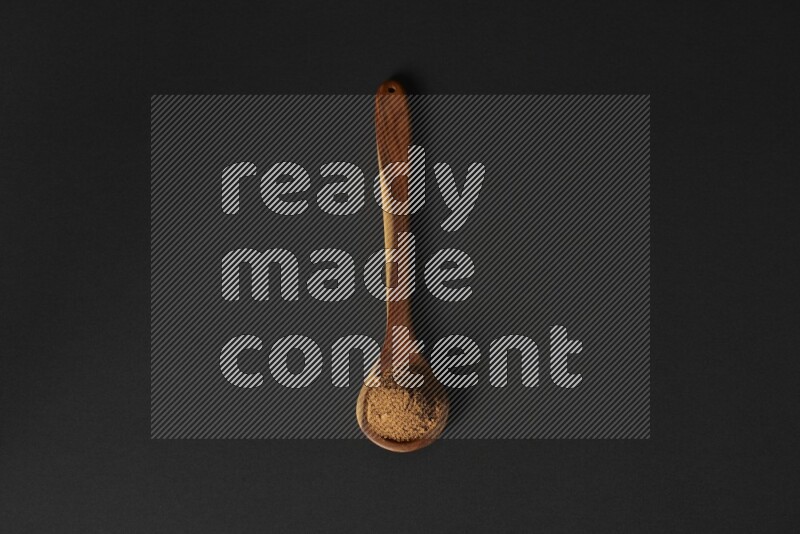 بودرة القرفة في مغرفة خشبية