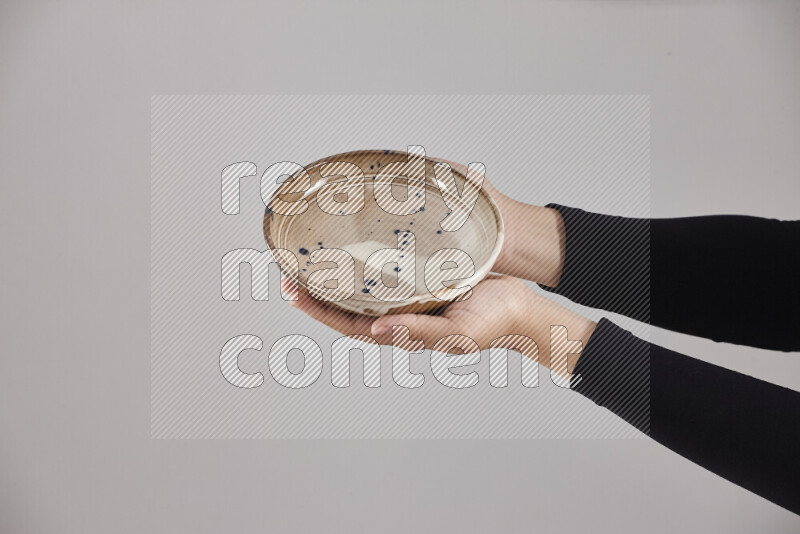 A woman in black abaya holding different pottery essentials in different positions