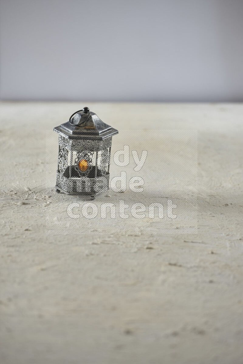 A lantern placed on a textured white background