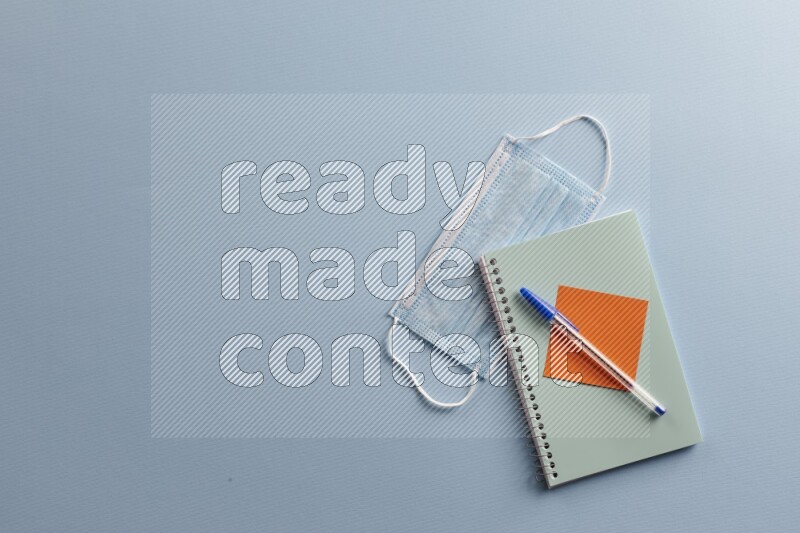 A blue notebook with different school supplies on blue background