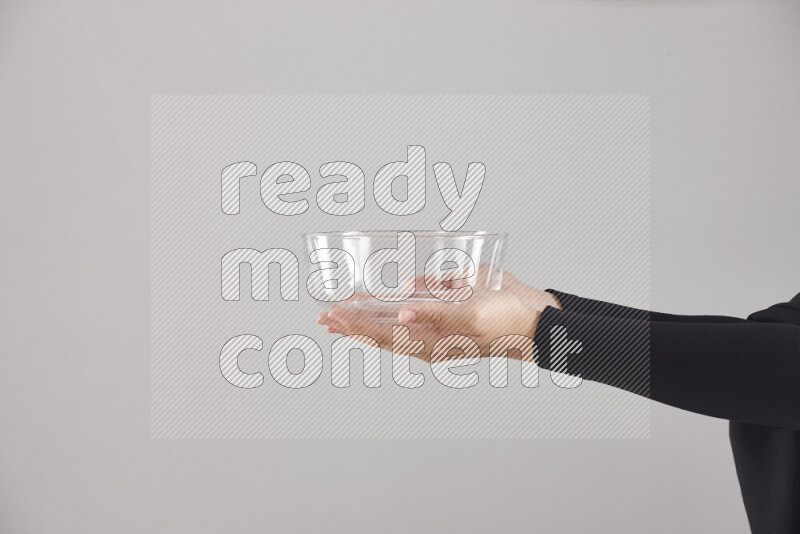 A woman in black abaya holding different glassware in different positions