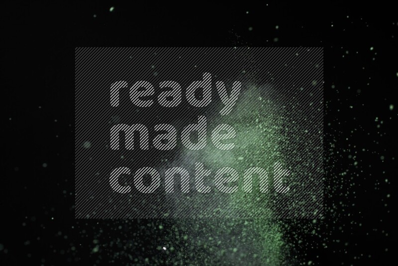 Green powder explosion on black background