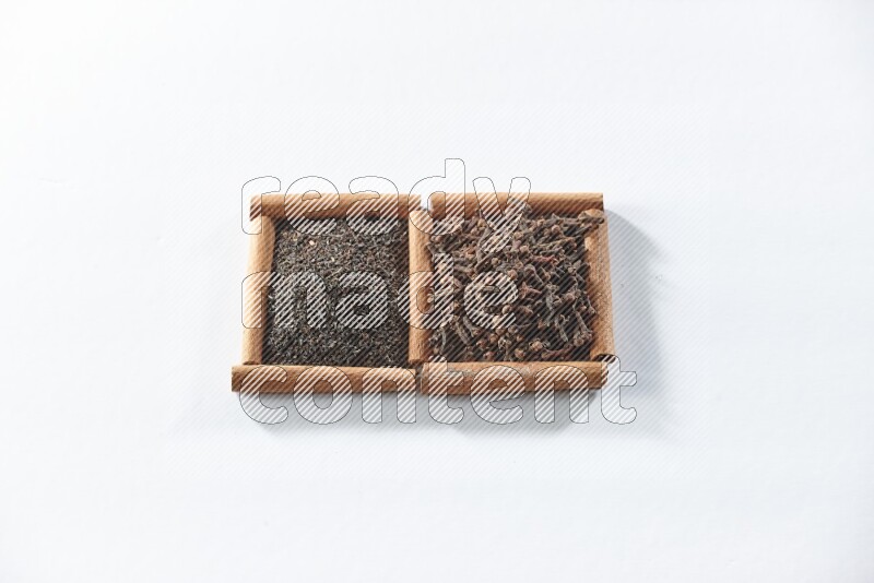 2 squares of cinnamon sticks full of black tea and cloves on white flooring