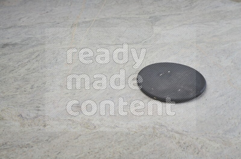 A flat pottery plate on grey marble background