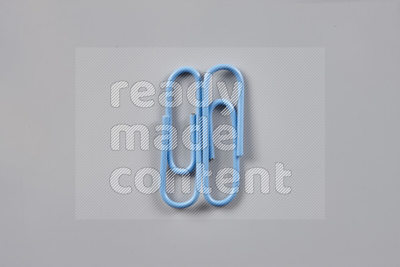 Blue paper clips isolated on a grey background