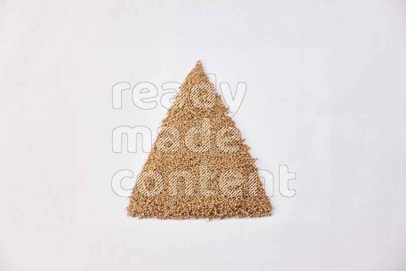 Mustard seeds in a triangle shape on a white flooring