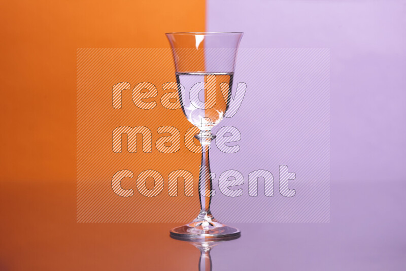 The image features a clear glassware filled with water, set against orange and light purple background