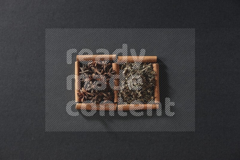 2 squares of cinnamon sticks full of star anise and dried basil on black flooring
