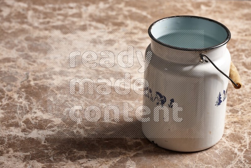 A vintage milk can on beige marble background