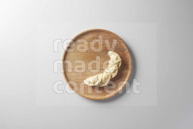 Four Sambosas on a wooden round plate on a white background