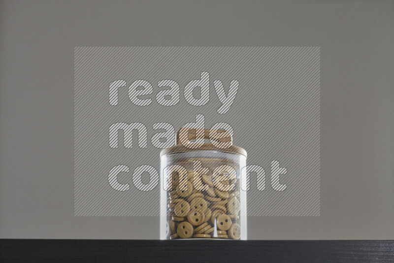 Buttons in a glass jar on black background